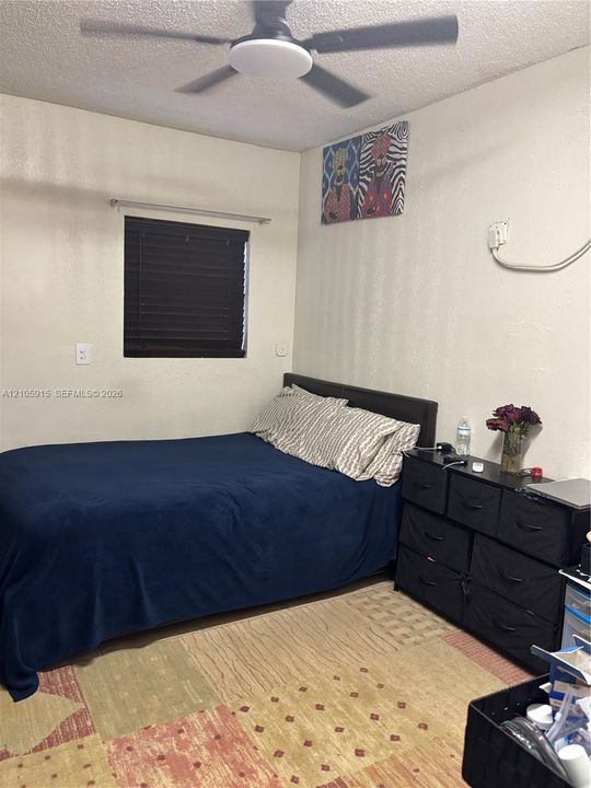Room featuring a ceiling fan with integrated lighting and a window with fitted blinds