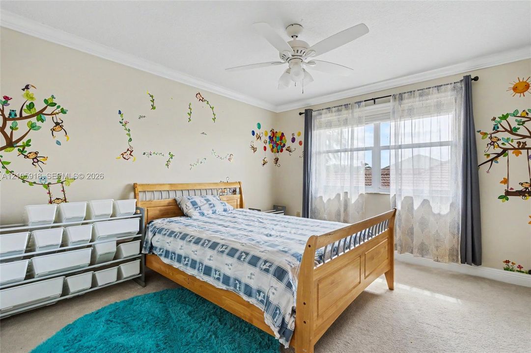 Neutral-toned room featuring crown molding, carpeting, and a central ceiling fan with integrated lighting