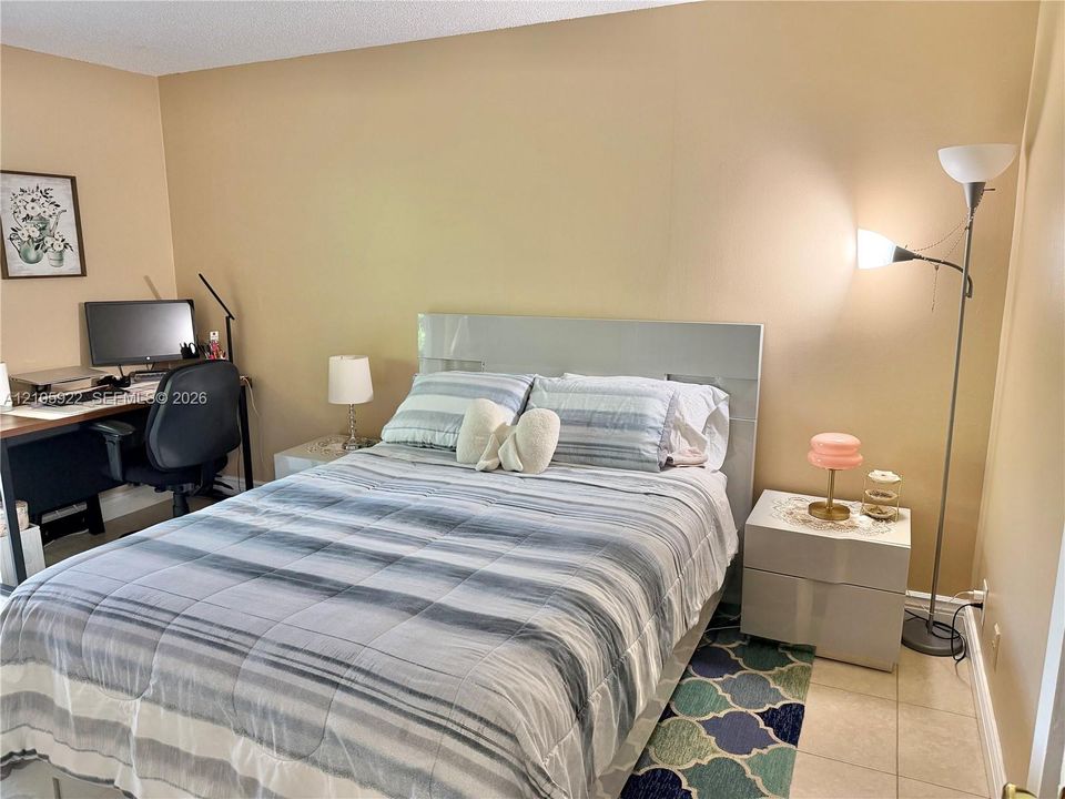 Neutral-toned interior featuring tiled flooring and a built-in headboard
