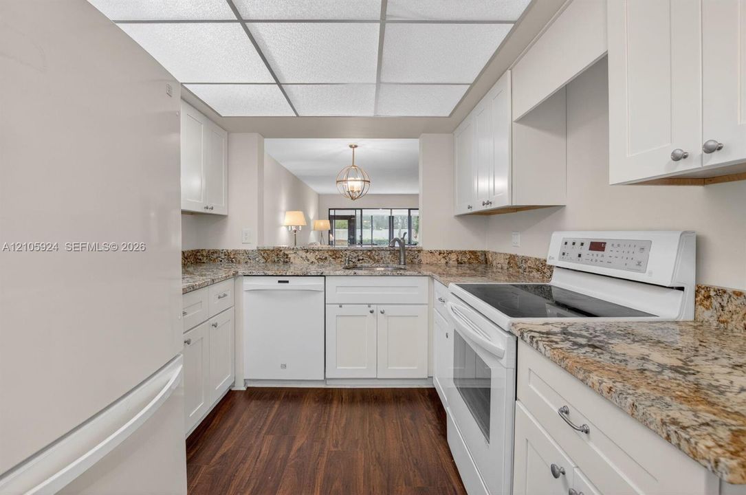 Kitchen featuring white cabinetry, stone-finish countertops, wood-finish flooring, and recessed ceiling lighting