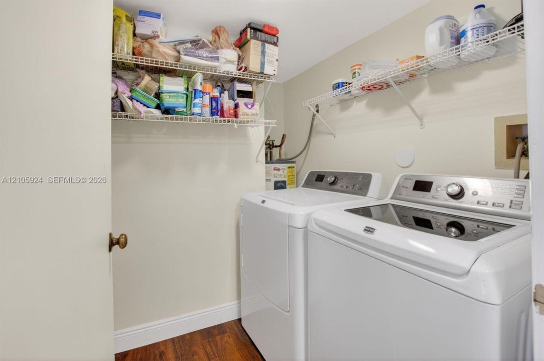 Laundry area featuring wood-finish flooring and dual wire-mesh wall shelving