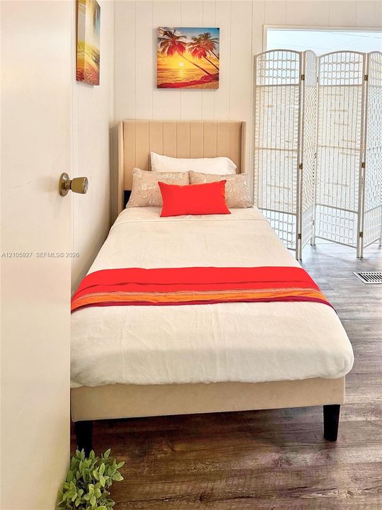 Room featuring vertical wall paneling and wood-finish flooring