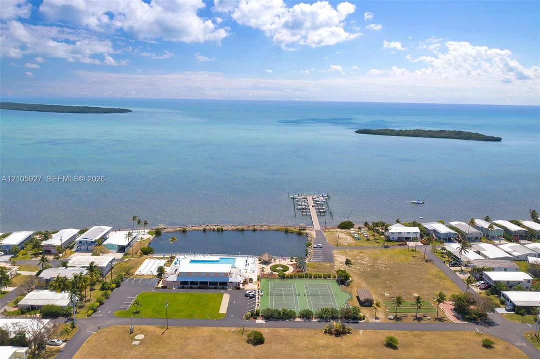 55+ Community  featuring a private boat dock, outdoor swimming pool, two tennis courts, and expansive coastal acreage
