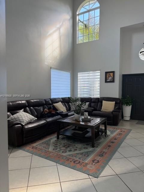 Vaulted ceilings featuring an arched window, tile flooring, and multiple dual-pane windows with horizontal blinds