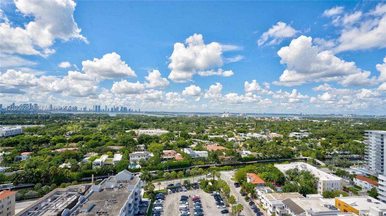 Elevated aerial perspective featuring expansive cityscape and horizon, lush canopy of mature trees, and waterfront canal elements