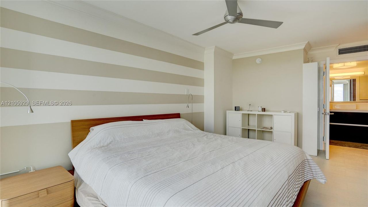 Interior room featuring crown molding, a multi-blade ceiling fan, and large-format tile flooring