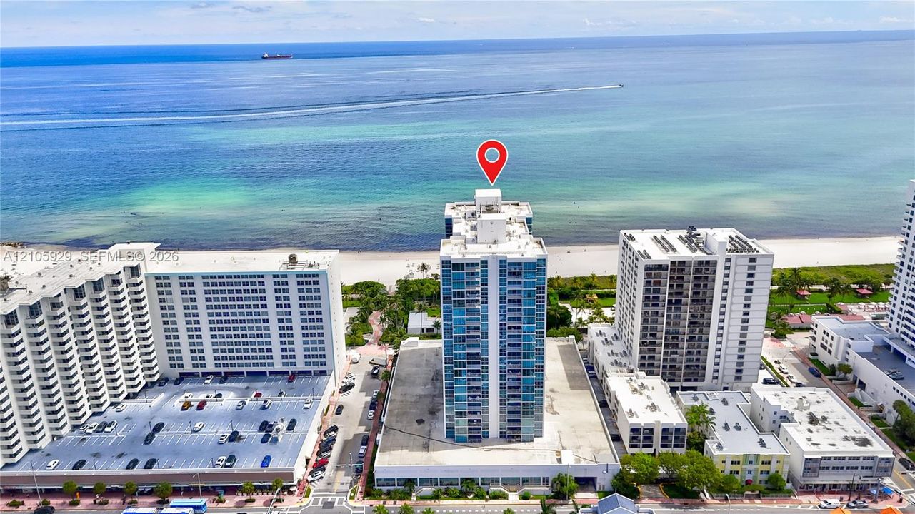 High-rise building featuring a glass facade, private balconies, and direct proximity to the oceanfront