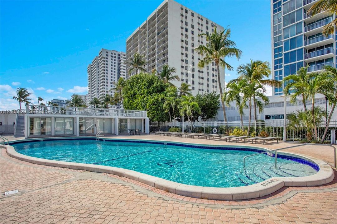 Swimming pool with paved surround, integrated stairs, and metal perimeter fencing