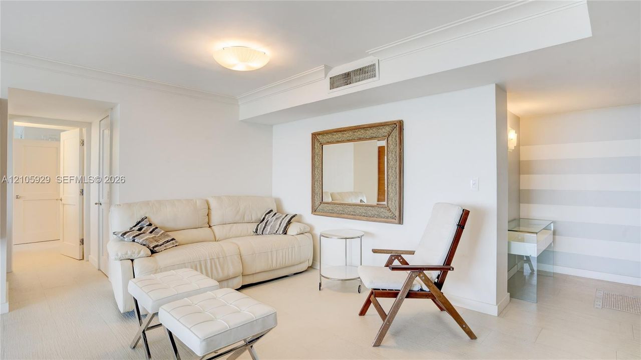 Interior space featuring neutral wall-to-wall carpeting, crown molding, a flush-mount ceiling light fixture, and a built-in recessed mirror