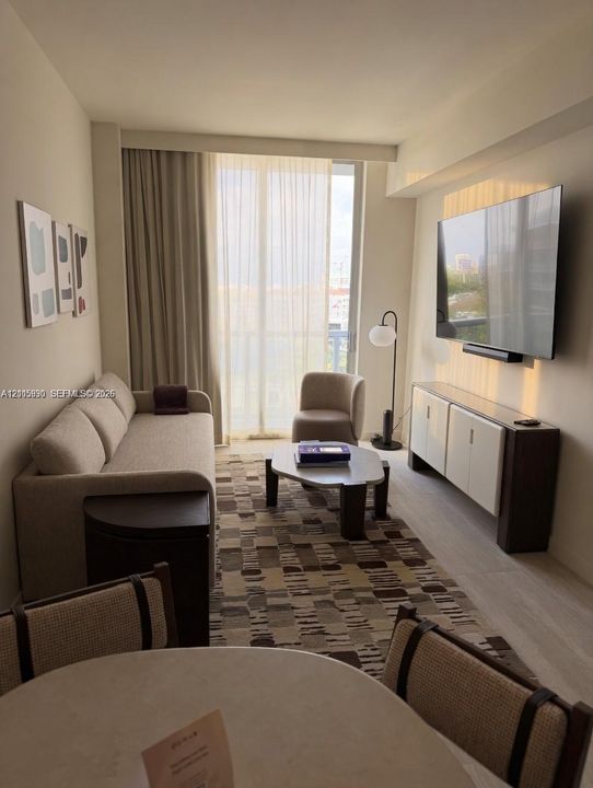Floor-to-ceiling sliding glass doors, neutral interior palette, and light-toned wood-finish flooring