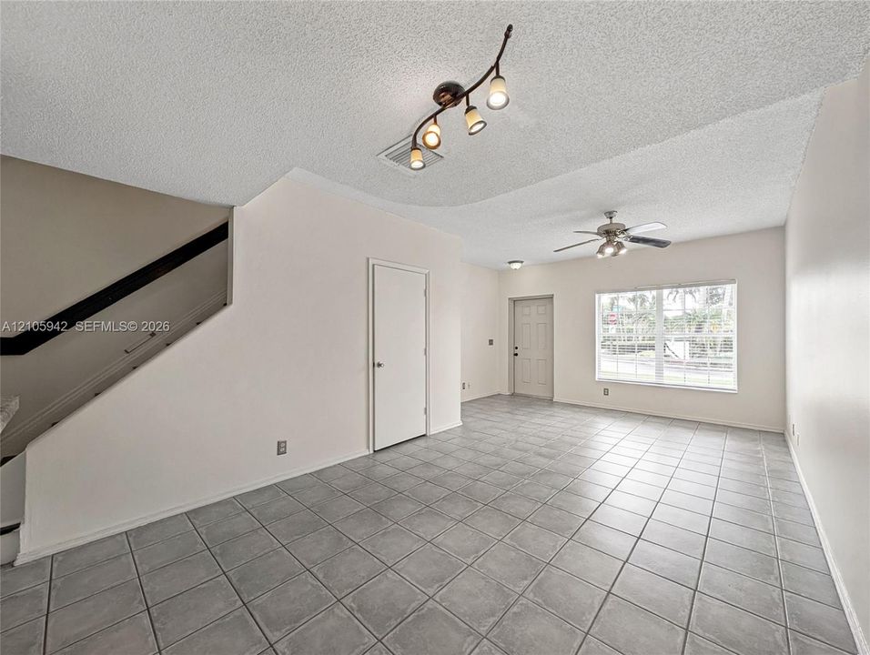living ceramic floor tile, vaulted ceilings, a ceiling fan with integrated lighting