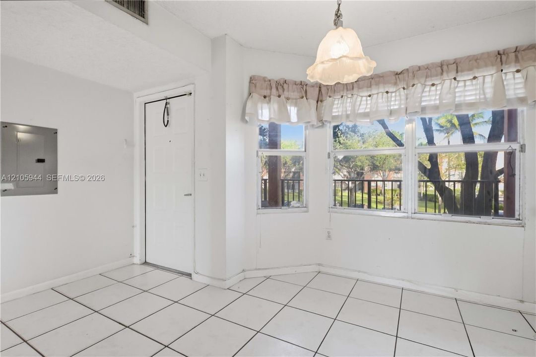 Ceramic tile flooring, bay window configuration, and an overhead pendant light fixture