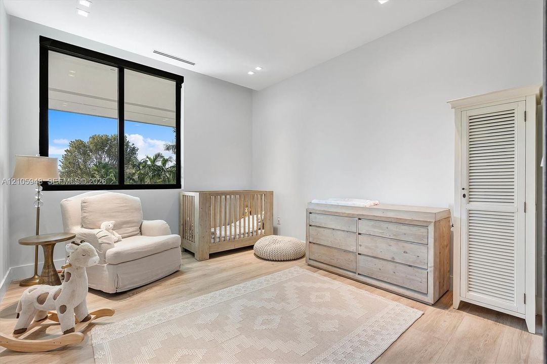 Room featuring light wood-finish flooring, large black-framed windows, and recessed ceiling lighting