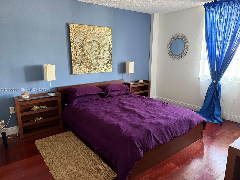 Wood-finish flooring throughout, smooth-texture wall surfaces, and a featured accent wall