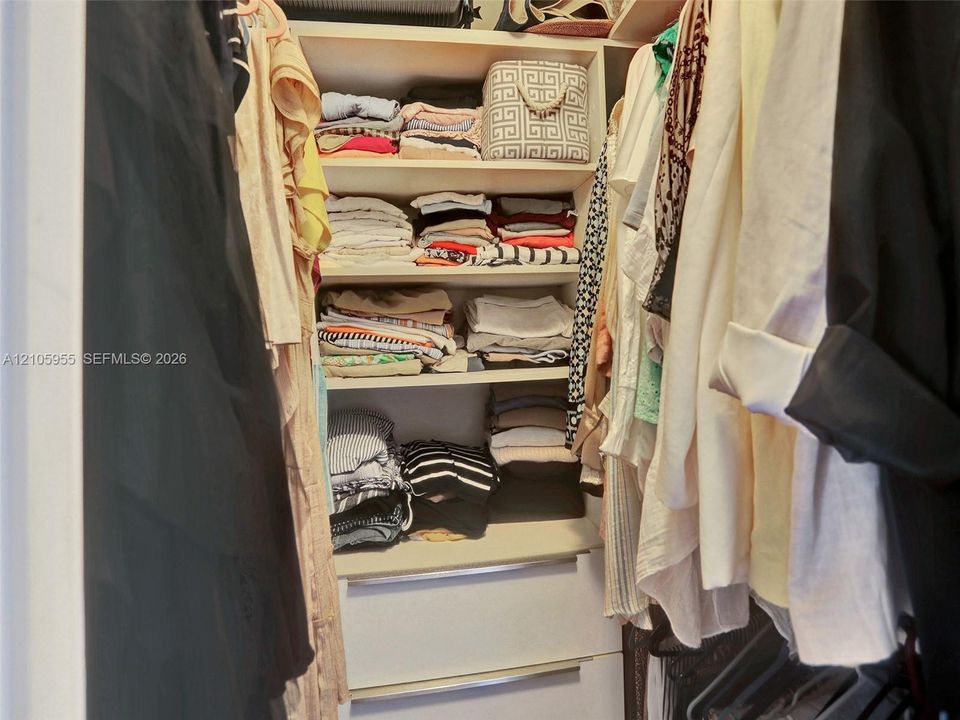 Closet featuring built-in shelving and two pull-out drawers with integrated hardware