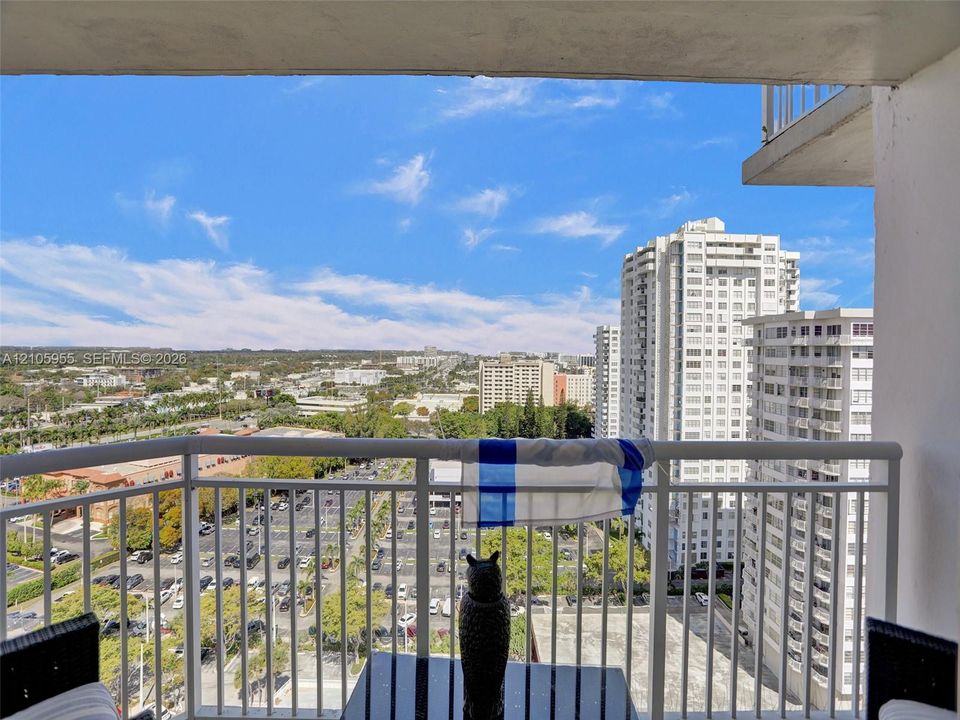 Private covered balcony featuring white metal railings