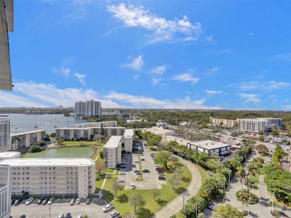 Elevated exterior perspective featuring expansive water scenery, multi-level residential structures, and landscaped grounds with mature palms