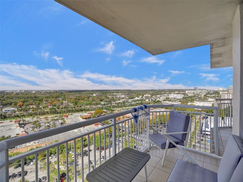 Covered balcony featuring tile flooring and a white metal safety railing with extensive panoramic exterior surroundings