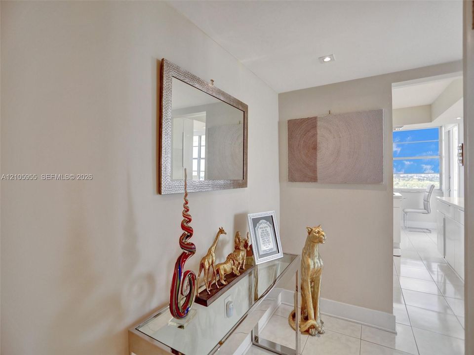 Neutral wall tones, high-gloss tile flooring, and recessed ceiling lighting