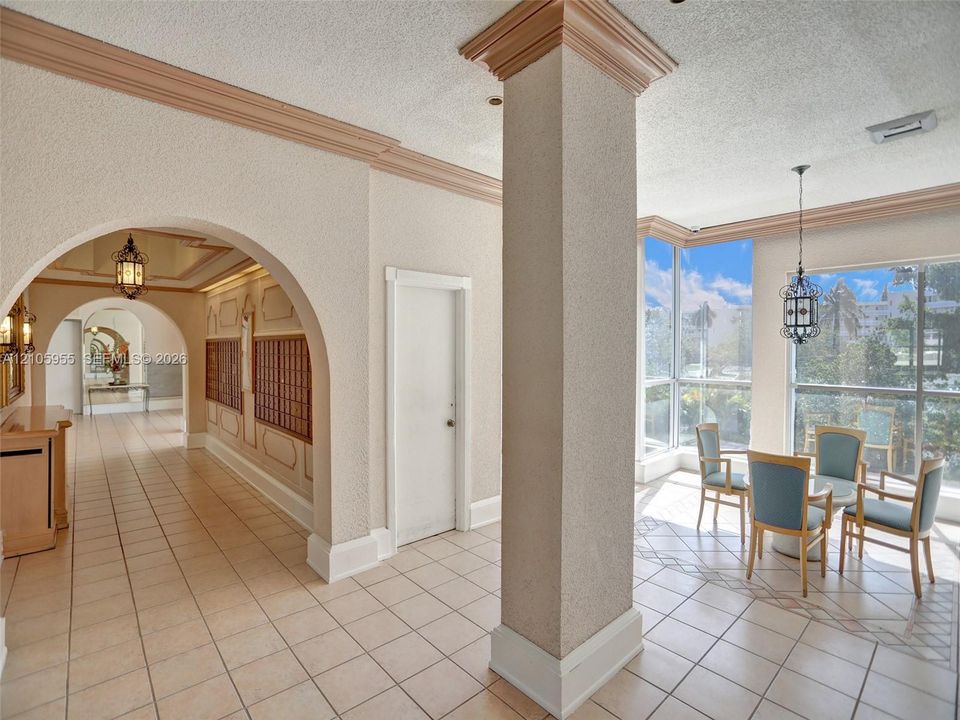 Common area featuring arched architectural detailing, ceramic tile flooring, floor-to-ceiling windows, and recessed lighting