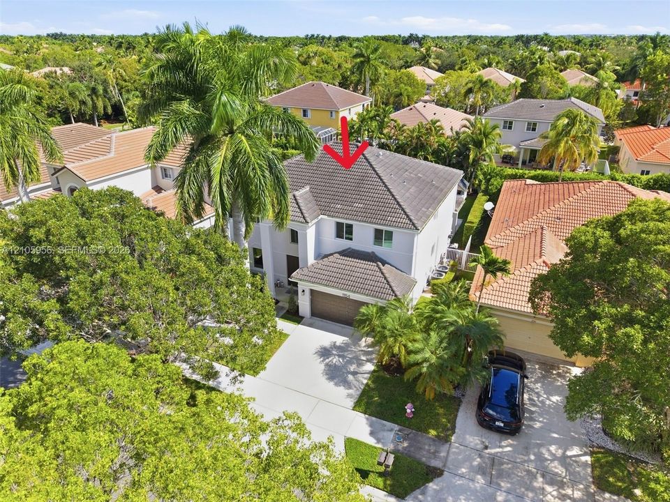 Two-story residence featuring a hipped tile roof, stucco exterior, integrated two-car garage, and a concrete driveway