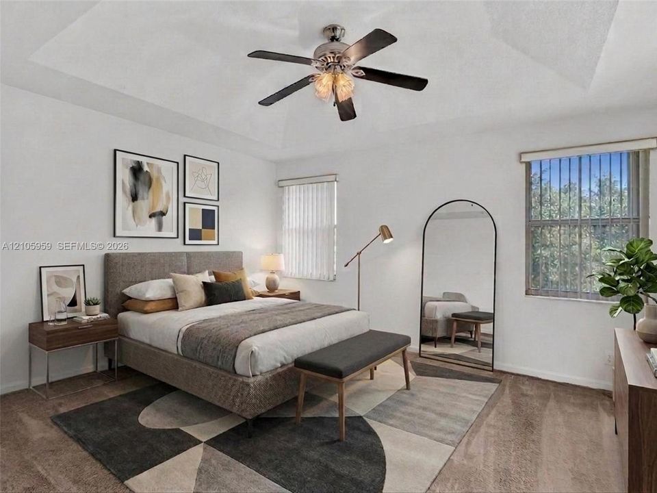 Tray ceiling featuring a central multi-blade ceiling fan with integrated lighting, neutral wall finishes, carpeted flooring, and dual windows
