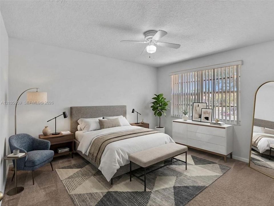 Spacious room featuring neutral carpeting, a white-finished ceiling fan with light fixture, and vertical window blinds