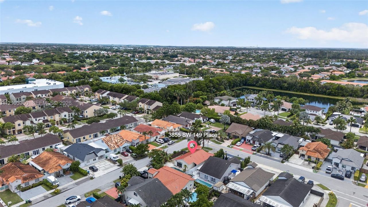 Aerial perspective of property featuring a tile roof, private swimming pool, and concrete driveway