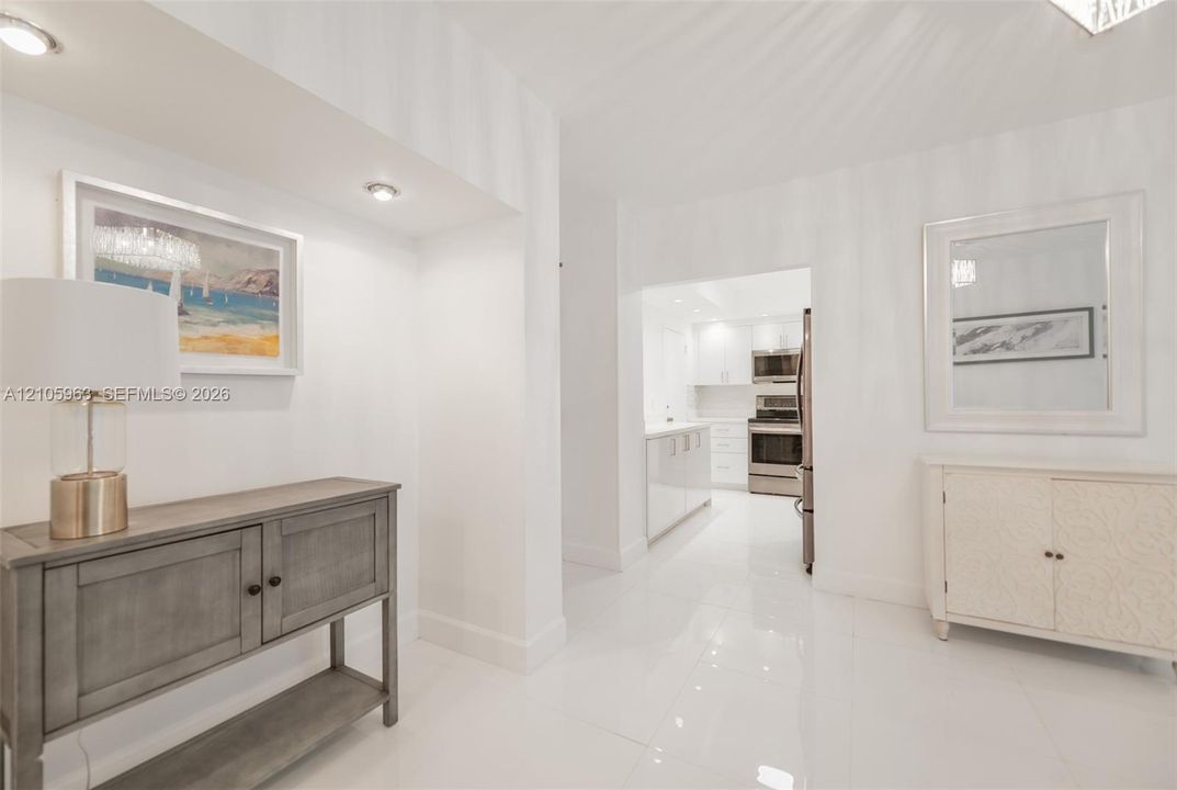 Polished tile flooring, recessed ceiling lighting, and white wall finishes