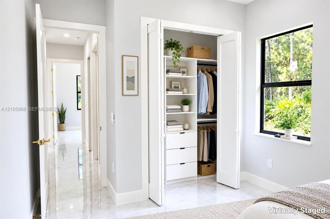 Built-in closet system with shelving and drawers, floor-to-ceiling bi-fold doors, large window with black frame, and polished tile flooring