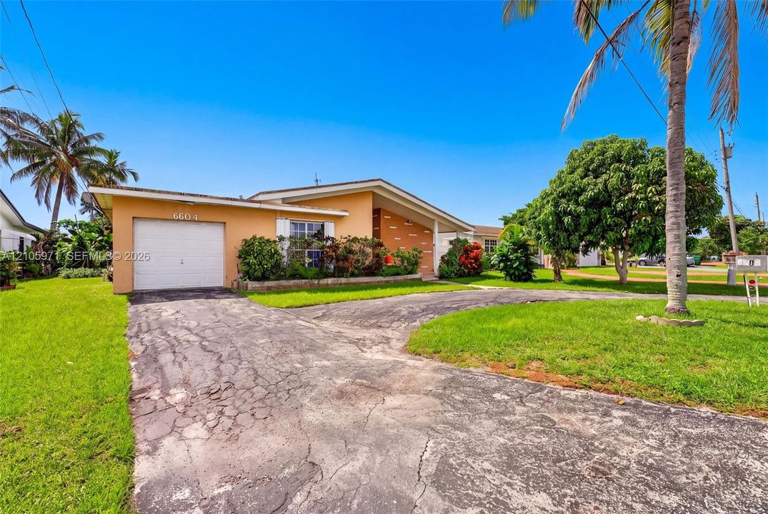 Single-story residence featuring a stucco exterior, attached one-car garage, and landscaped front yard with mature palms