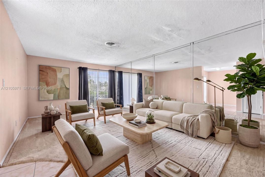 Living area featuring floor-to-ceiling wall mirror panels, sliding glass doors, and light-toned carpeting