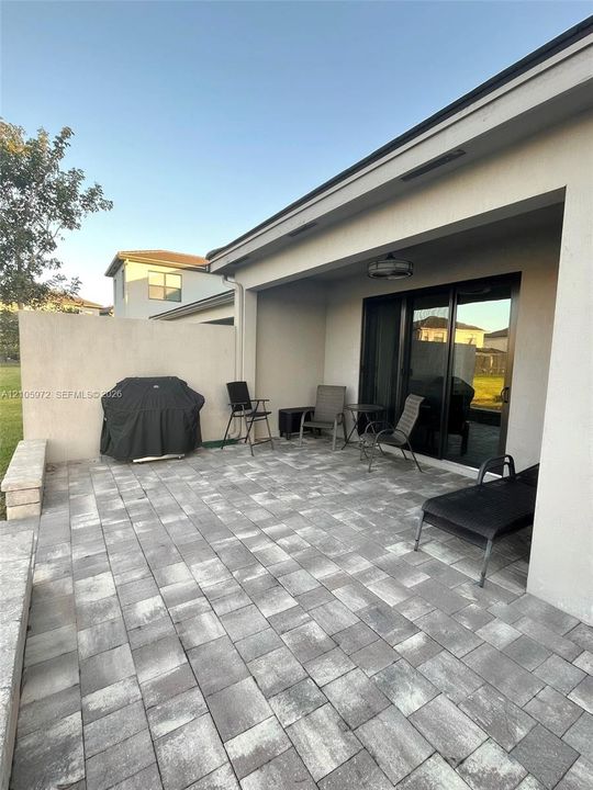 Covered patio featuring concrete paver flooring, a perimeter masonry privacy wall, and recessed ceiling lighting