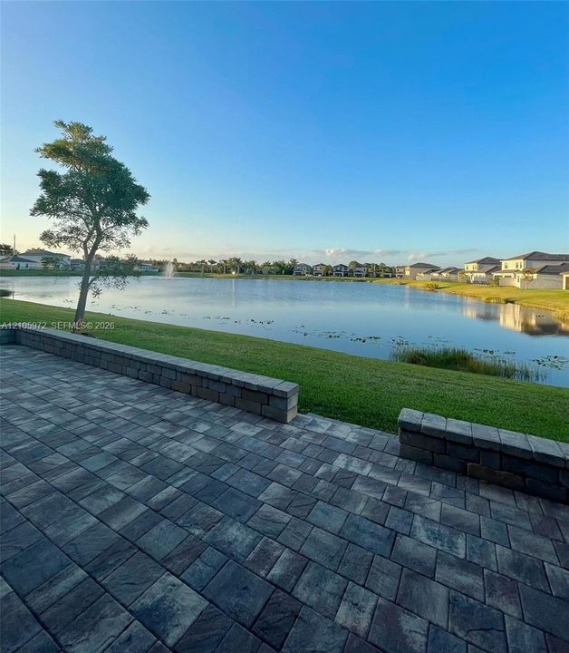 Paver patio featuring integrated stone block seating walls and expansive waterfront exposure