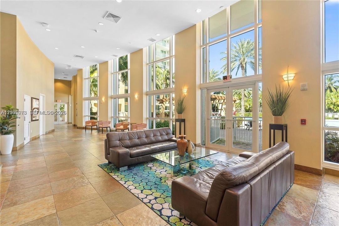 Floor-to-ceiling windows, high ceilings, recessed lighting, and tile flooring