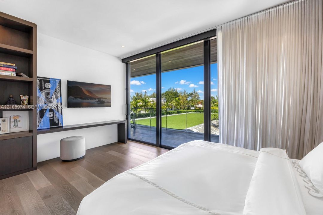 Floor-to-ceiling sliding glass doors, built-in floor-to-ceiling shelving, wood-finish flooring, and integrated wall-mounted desk