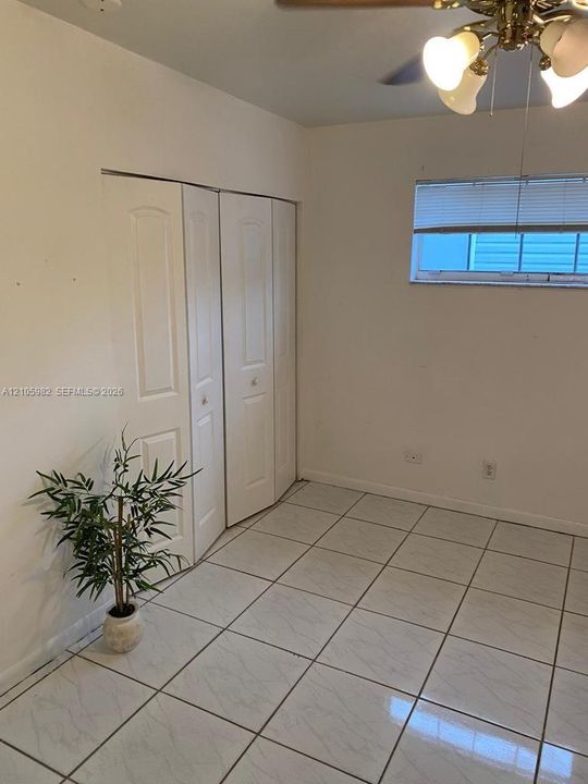 Interior space featuring tile flooring, bi-fold closet doors, and a ceiling-mounted light fixture