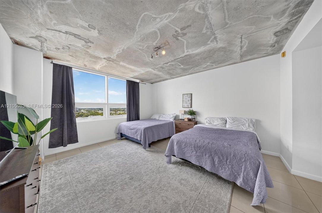 Exposed concrete ceiling, large-format tile flooring, and floor-to-ceiling windows