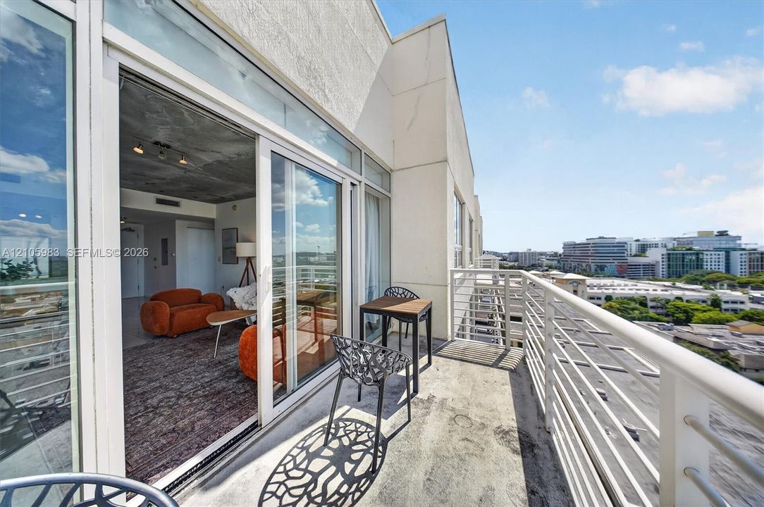 Private balcony featuring a concrete surface, metal railing, and floor-to-ceiling glass sliding doors