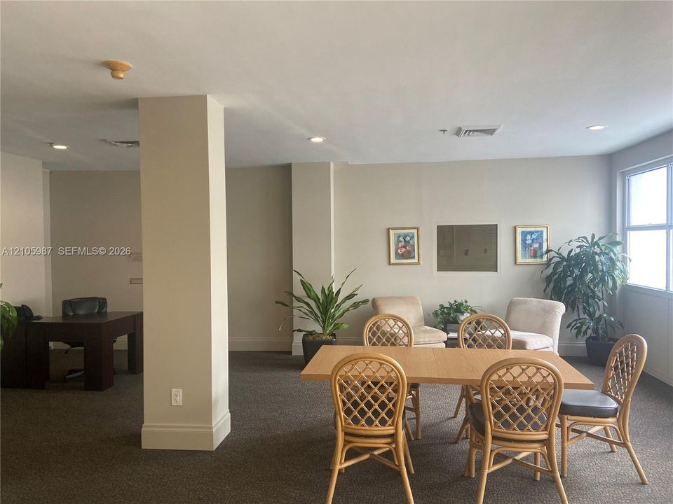 Spacious room featuring neutral wall tones, recessed lighting, carpeted flooring, and large windowed natural light exposure