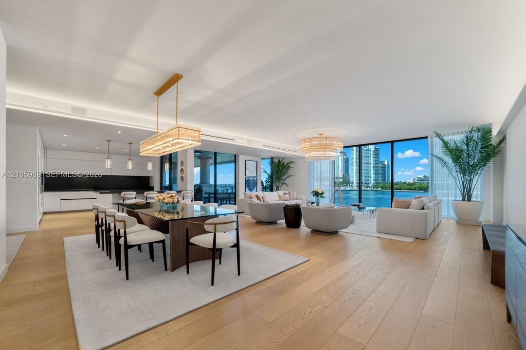 Open-concept living space featuring wood-finish flooring, floor-to-ceiling windows, recessed lighting, and a modern linear chandelier