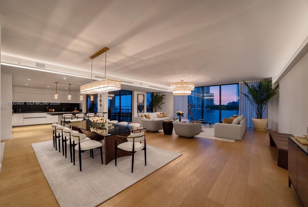 Open-concept interior featuring wood-finish flooring, recessed LED cove lighting, floor-to-ceiling glass windows, contemporary pendant lighting, and flat-panel cabinetry