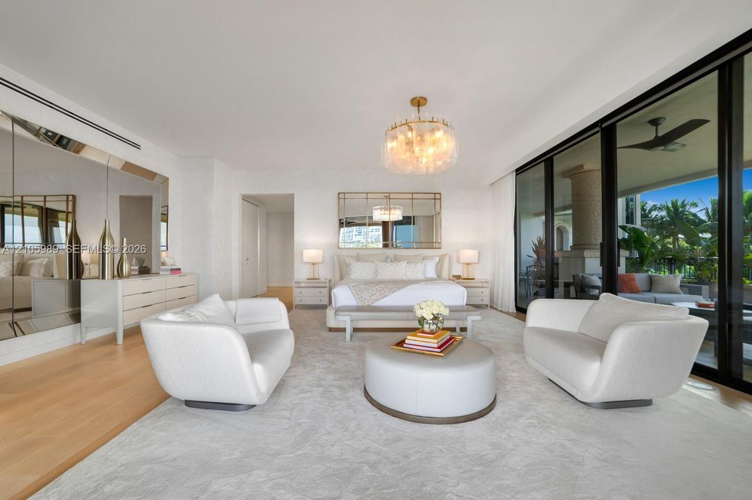 Floor-to-ceiling glass sliding doors, wood-finish flooring, recessed linear lighting, custom wall-to-wall mirror paneling, and an oversized decorative chandelier