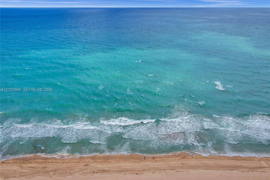Direct oceanfront access with expansive sandy beach frontage and unobstructed water scenery