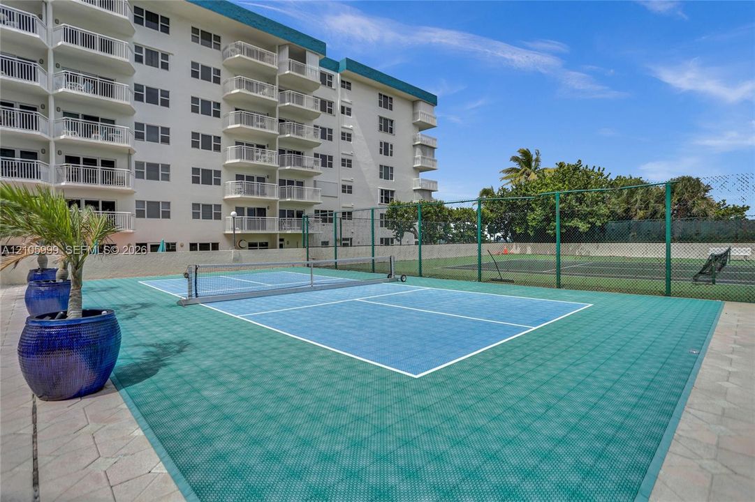 Pickleball court featuring modular athletic flooring and perimeter chain-link fencing