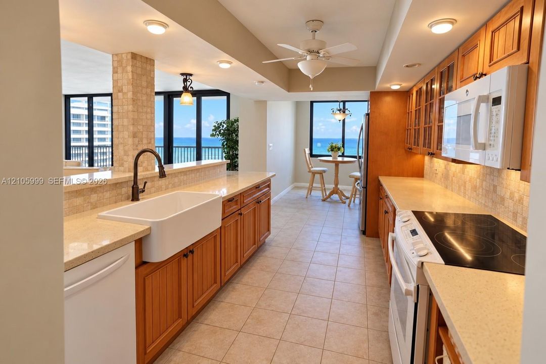 Kitchen featuring wood cabinetry, stone-finish countertops, ceramic tile backsplash, farmhouse-style sink, and built-in appliances