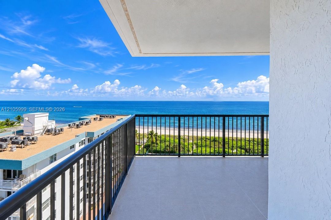 Private balcony featuring tile flooring and black metal railings with an expanse of ocean scenery