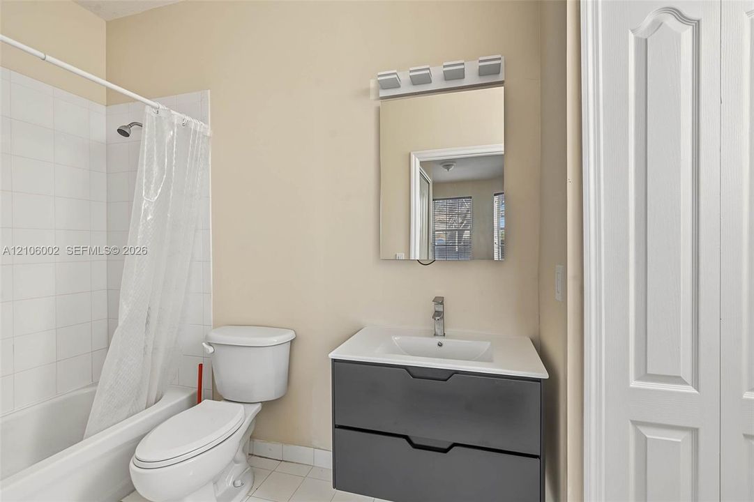 Modern vanity featuring a charcoal-finished dual-drawer cabinet, white countertop with integrated sink, and polished chrome faucet