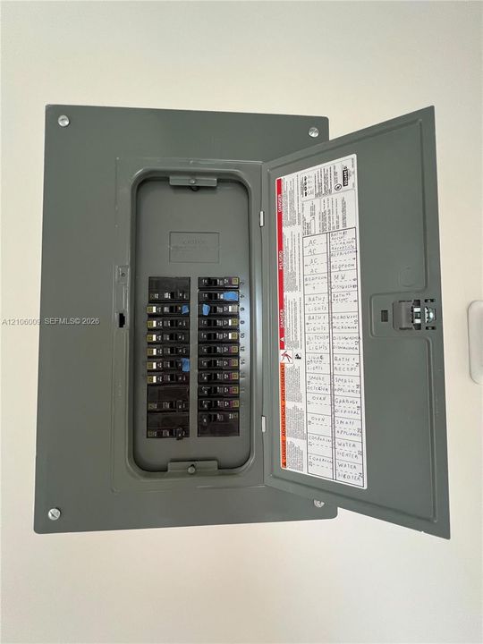 Electrical service panel featuring a multi-circuit breaker configuration with a hinged metal door and clearly labeled directory