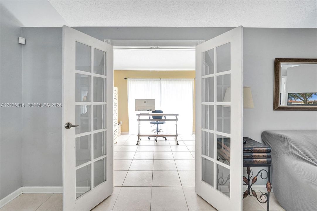 White-framed French doors with glass panes and ceramic tile flooring
